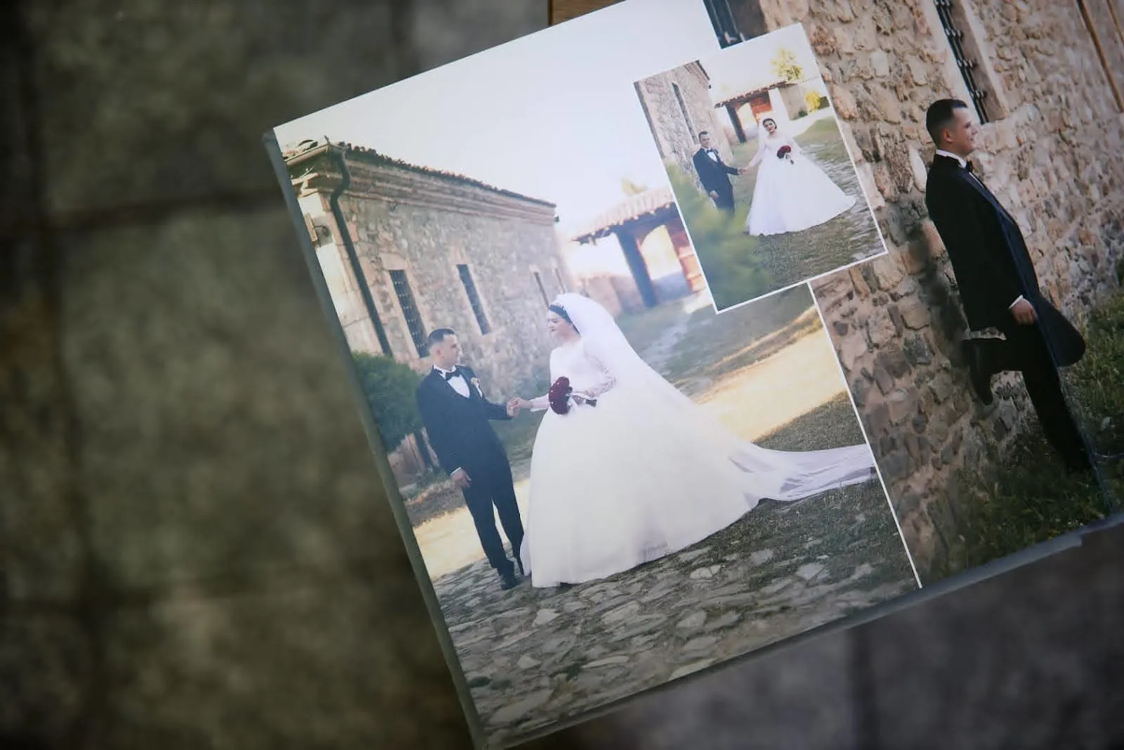 A wedding photo album showing the bride and groom walking together near a stone building.