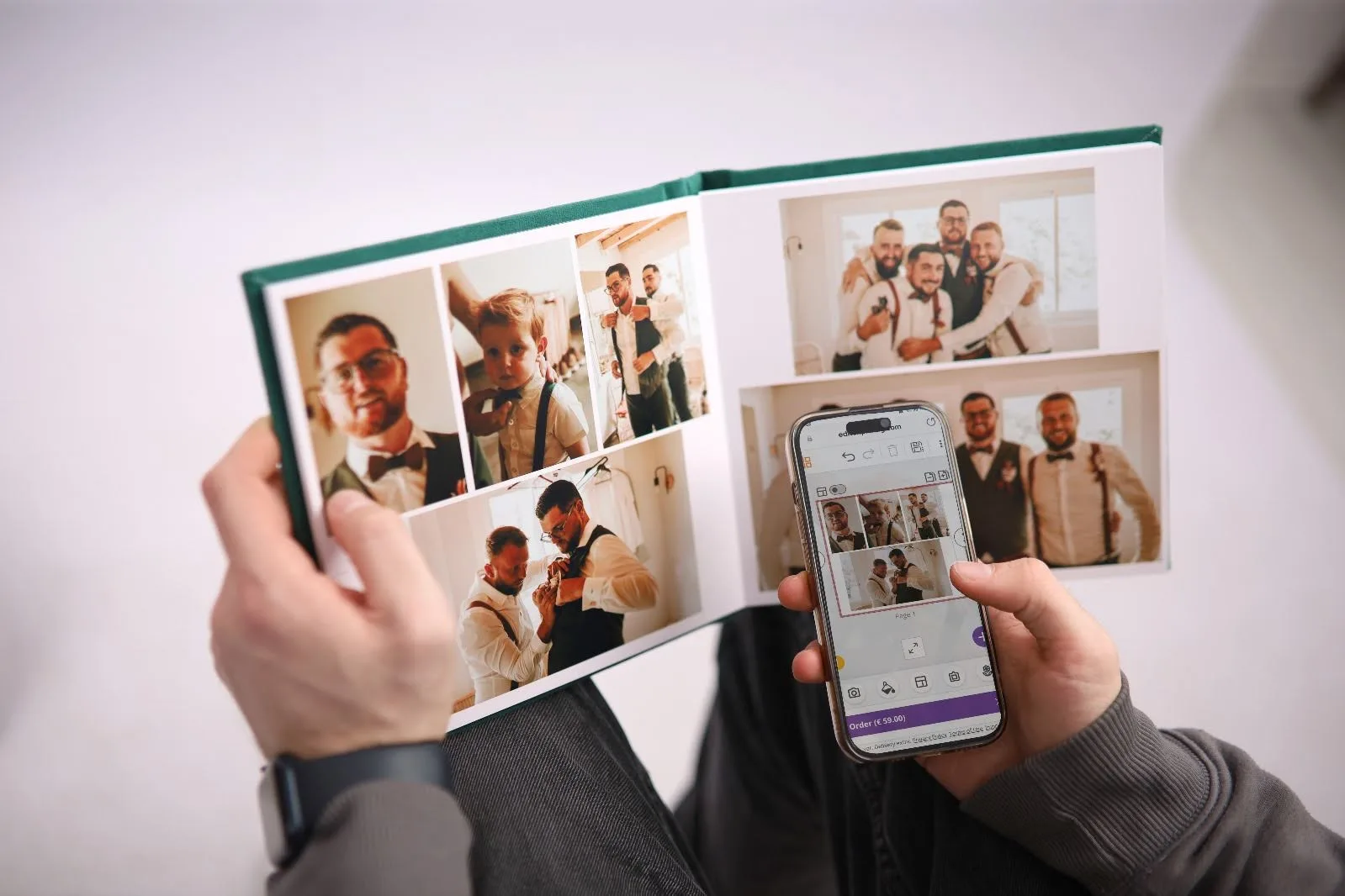 A person holding a photo album physically while using a phone to view the same photos, It shows that the album has been digitized to keep the memories safe.